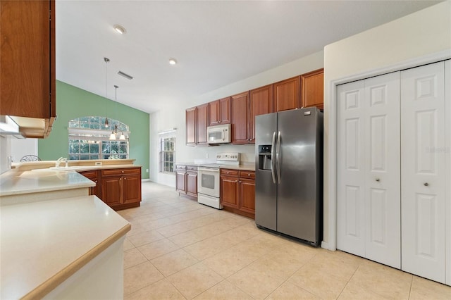 kitchen featuring light tile patterned floors, hanging light fixtures, sink, and white appliances