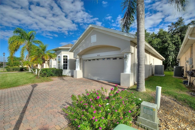 ranch-style house with central AC, a garage, and a front lawn