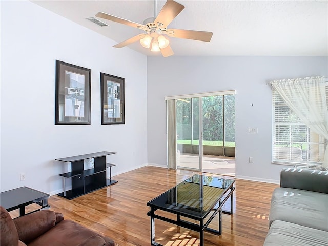 living room with vaulted ceiling, wood-type flooring, a healthy amount of sunlight, and ceiling fan