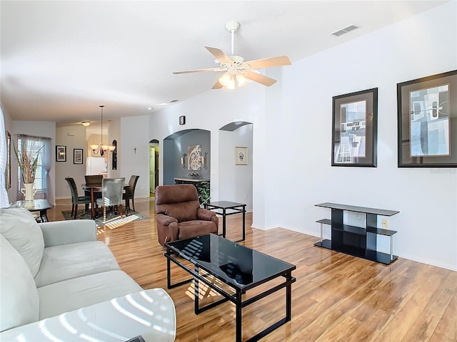 living room featuring hardwood / wood-style flooring and ceiling fan with notable chandelier