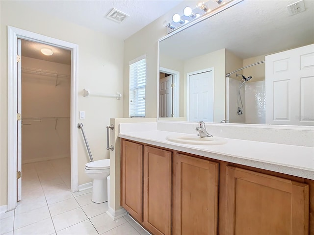 bathroom featuring tile patterned floors, toilet, a shower, vanity, and a textured ceiling