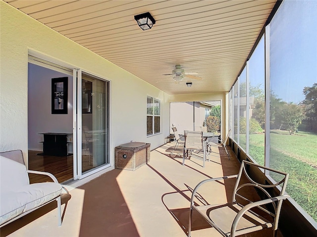 sunroom / solarium featuring a healthy amount of sunlight and ceiling fan