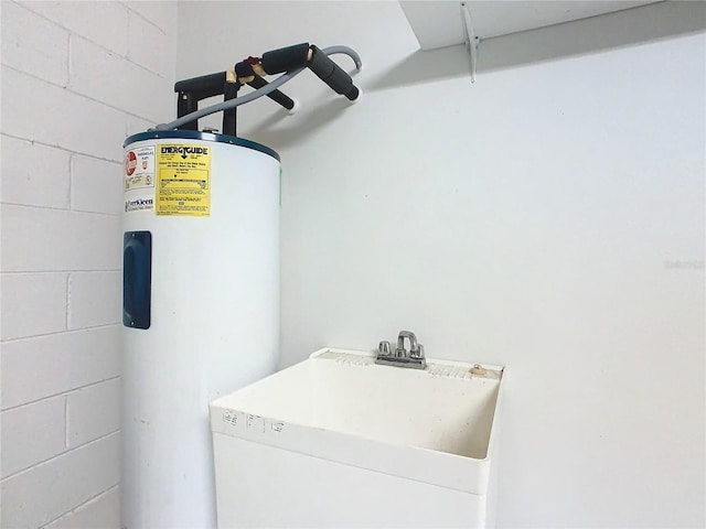 clothes washing area featuring electric water heater and sink