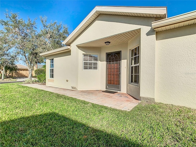 doorway to property with a yard