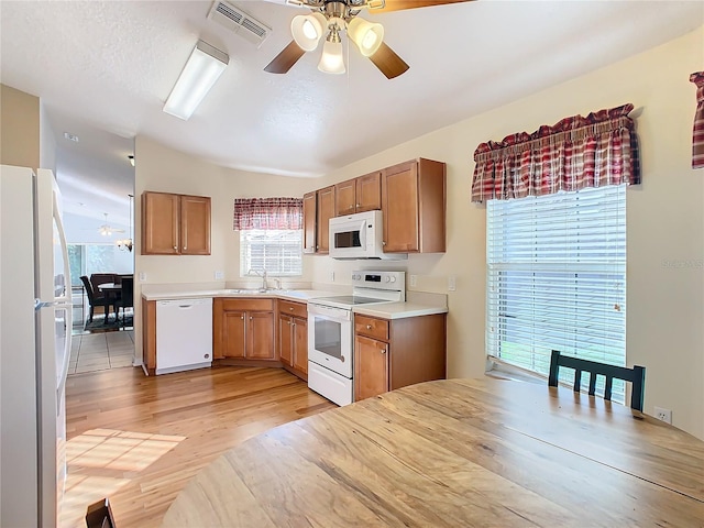 kitchen featuring white appliances, sink, light hardwood / wood-style floors, ceiling fan, and lofted ceiling