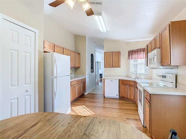 kitchen featuring light hardwood / wood-style flooring, sink, vaulted ceiling, white appliances, and ceiling fan