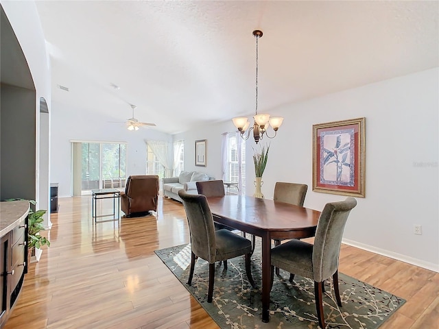 dining space with light wood-type flooring and ceiling fan with notable chandelier