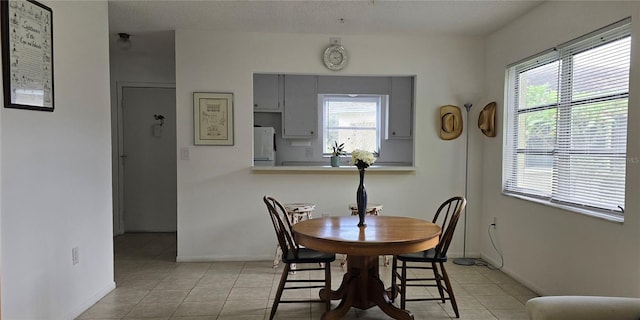 tiled dining area featuring a textured ceiling