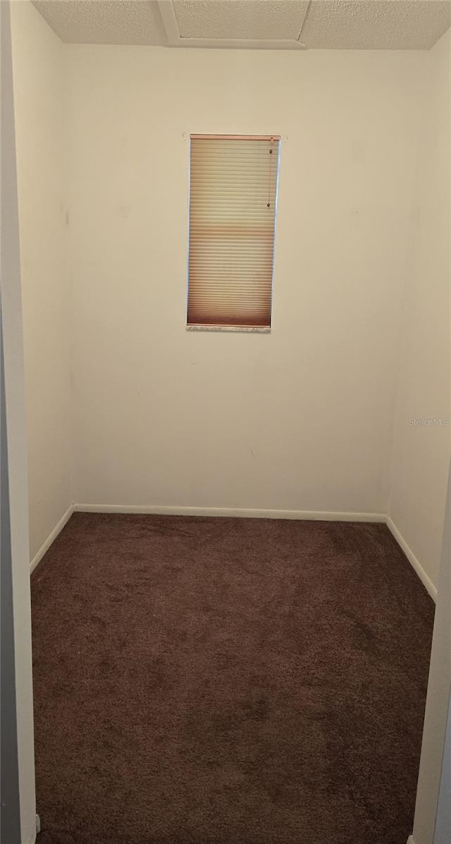 carpeted empty room featuring a textured ceiling