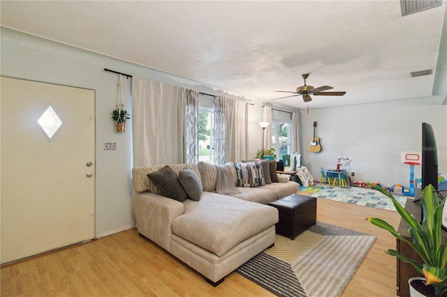 living room with wood-type flooring and ceiling fan