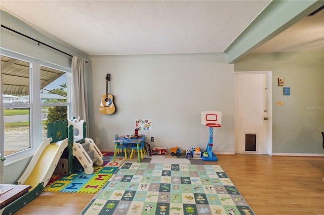 game room with a textured ceiling and hardwood / wood-style flooring