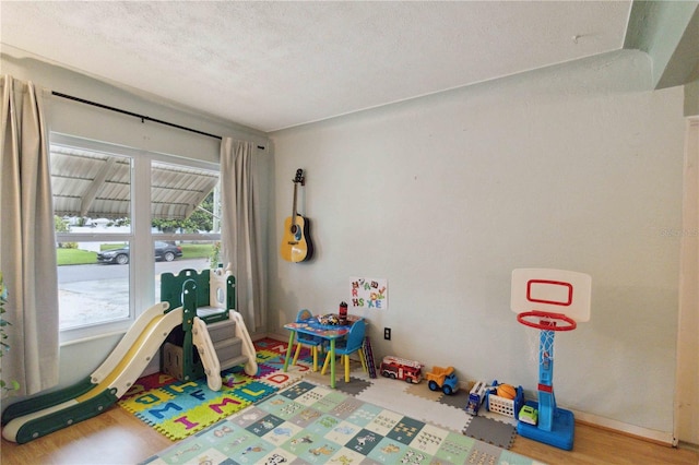 rec room with hardwood / wood-style floors and a textured ceiling