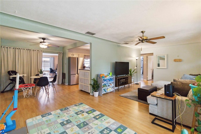 living room with light wood-type flooring and ceiling fan