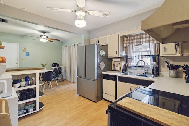 kitchen with decorative backsplash, exhaust hood, light hardwood / wood-style floors, sink, and white appliances