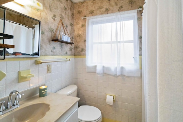 bathroom featuring tile walls, vanity, curtained shower, and toilet