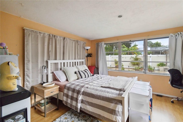 bedroom featuring a textured ceiling and light wood-type flooring