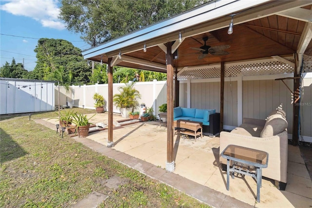 view of patio / terrace featuring a fenced backyard, an outdoor living space, a shed, and ceiling fan