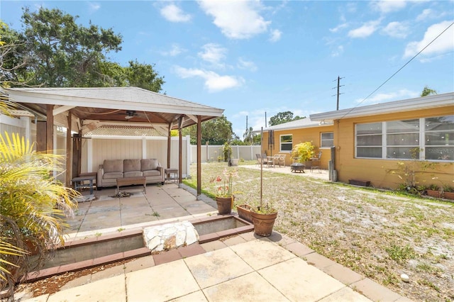view of patio / terrace with a fenced backyard, outdoor lounge area, a ceiling fan, and a gazebo