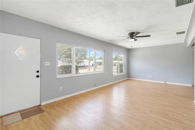 foyer entrance featuring baseboards, visible vents, light wood-style floors, and ceiling fan