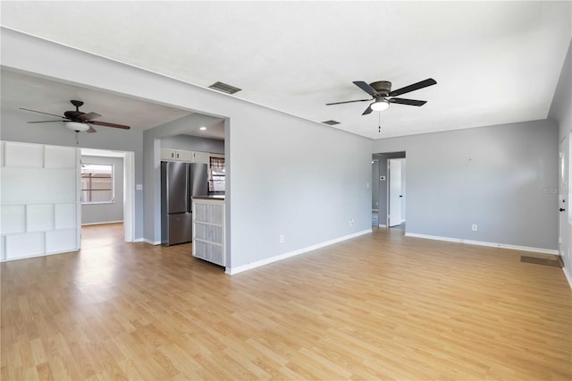 unfurnished living room featuring light wood-style floors, a ceiling fan, and baseboards