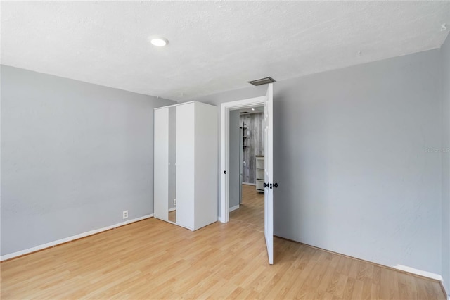 interior space with visible vents, light wood finished floors, and baseboards