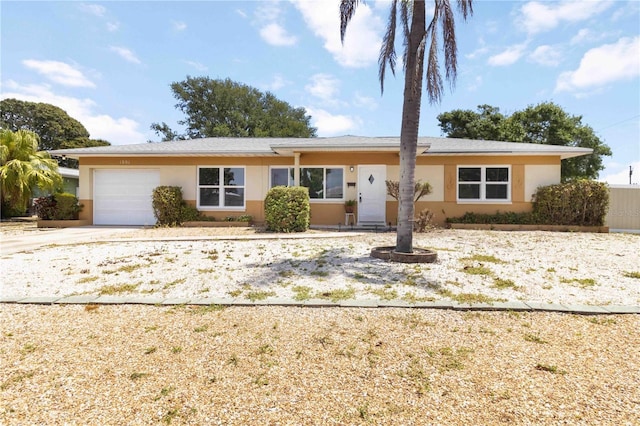 ranch-style house with an attached garage, concrete driveway, and stucco siding