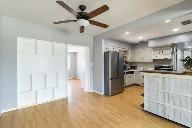 kitchen featuring light wood finished floors, visible vents, baseboards, light countertops, and appliances with stainless steel finishes