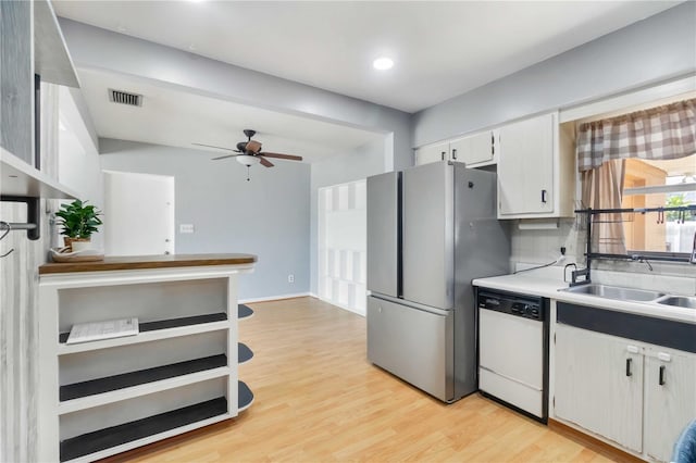kitchen featuring a sink, white dishwasher, a ceiling fan, light wood-style flooring, and freestanding refrigerator