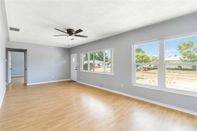 unfurnished room featuring baseboards, a ceiling fan, visible vents, and light wood-type flooring