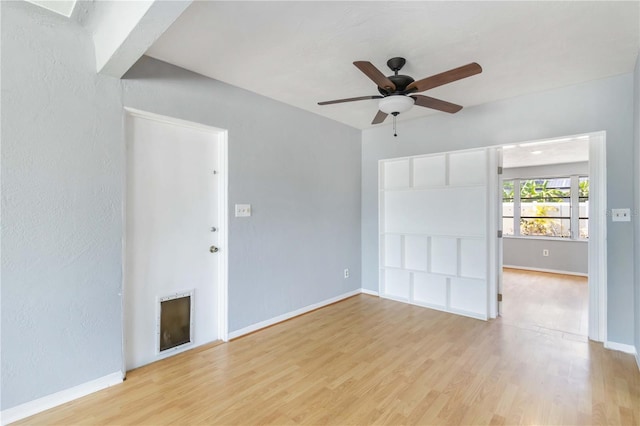 interior space with ceiling fan, baseboards, light wood-style floors, and a fireplace