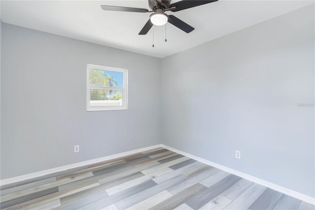 empty room featuring wood finished floors, a ceiling fan, and baseboards