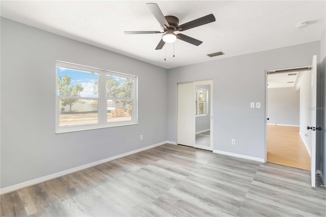 unfurnished bedroom with light wood finished floors, visible vents, and baseboards