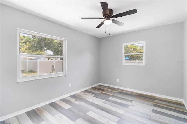 spare room featuring ceiling fan, wood finished floors, and baseboards