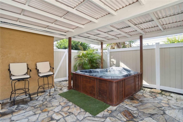 view of patio / terrace with a fenced backyard and a hot tub