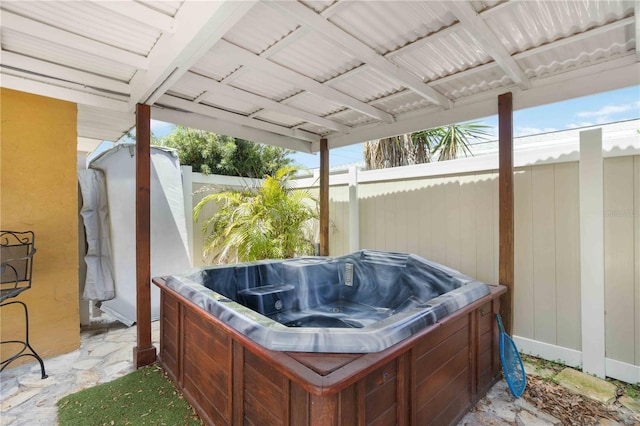 view of patio / terrace featuring fence and a hot tub