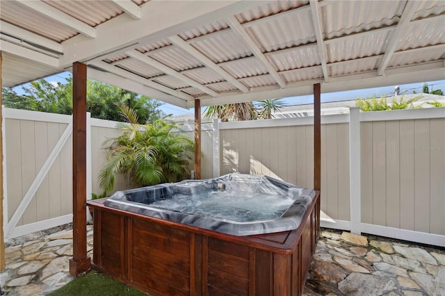 view of patio with fence and a hot tub