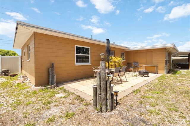 rear view of house with a patio, an outdoor fire pit, and fence