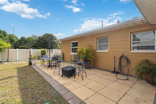 view of patio featuring an outdoor fire pit and fence