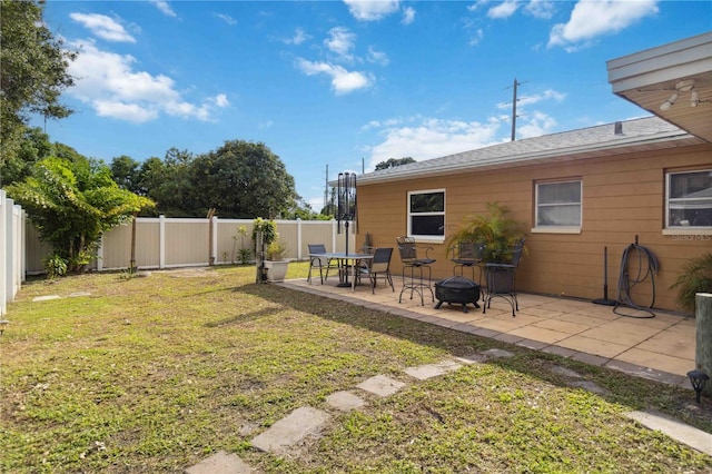 view of yard featuring a fire pit, a fenced backyard, and a patio