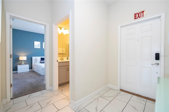 foyer entrance featuring baseboards and marble finish floor