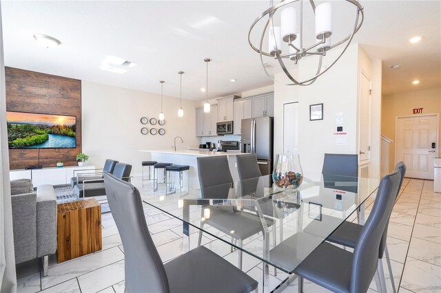 dining area featuring sink and a chandelier