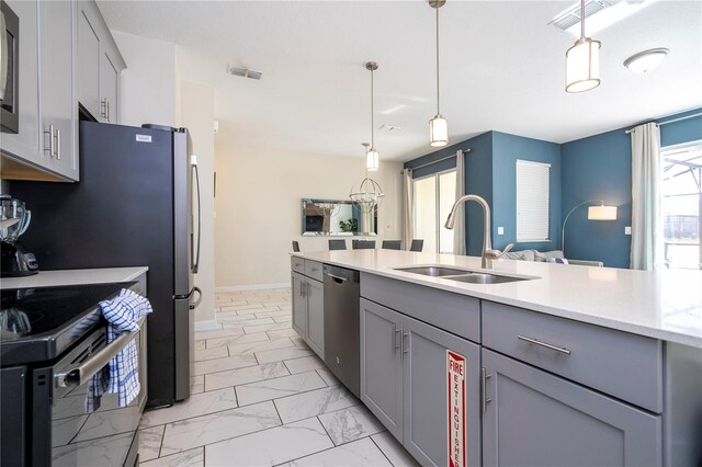 kitchen featuring sink, appliances with stainless steel finishes, decorative light fixtures, and gray cabinetry