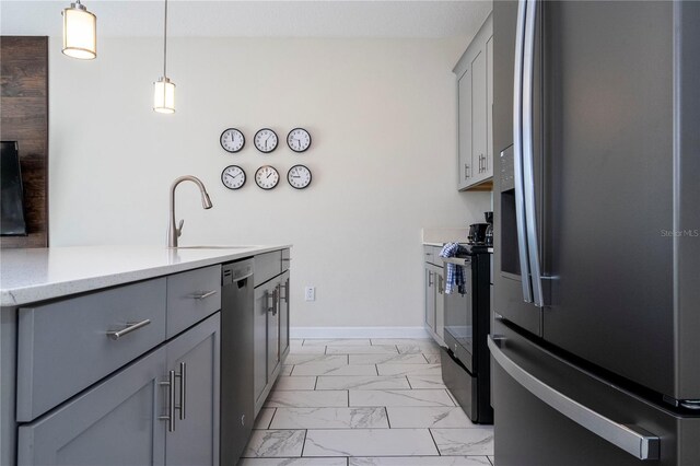 kitchen featuring pendant lighting, sink, gray cabinetry, and stainless steel appliances