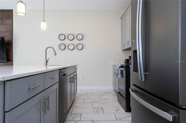 kitchen with a sink, gray cabinetry, stainless steel appliances, and marble finish floor