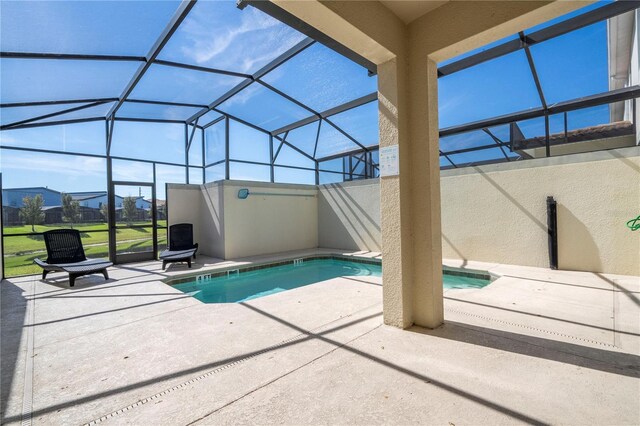 outdoor pool with glass enclosure and a patio area