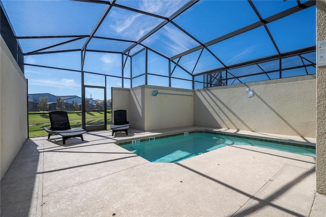 outdoor pool with a patio and glass enclosure