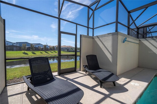 sunroom featuring a water view