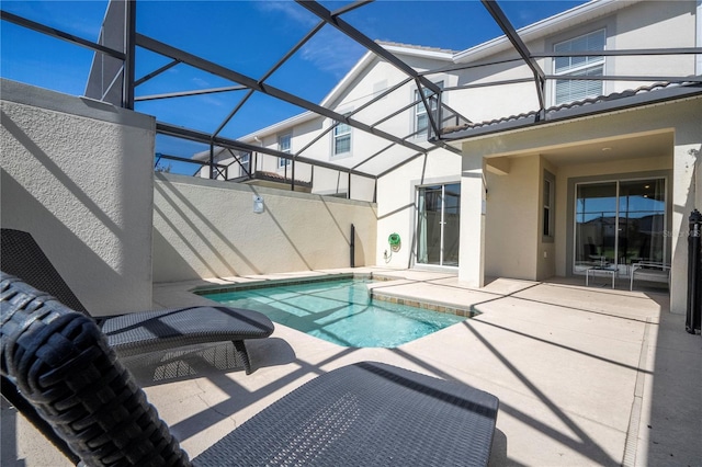 outdoor pool with glass enclosure and a patio area