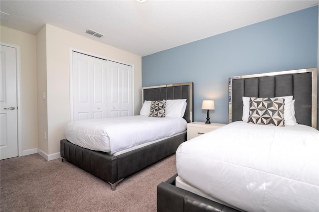 carpeted bedroom featuring visible vents, baseboards, and a closet