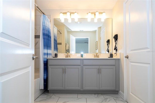 bathroom featuring double vanity, a sink, and marble finish floor